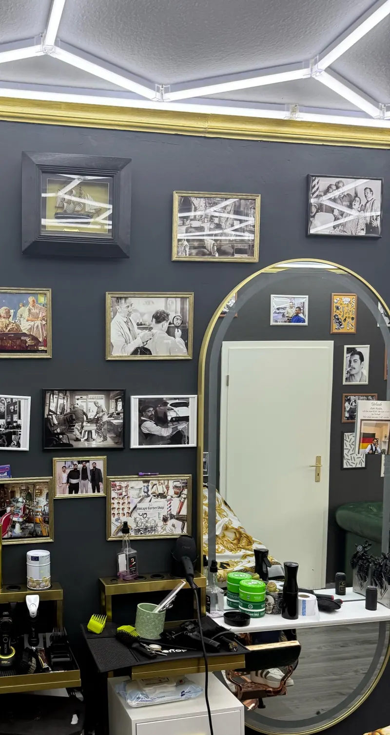 Spiegel mit Goldrahmen und historische Barbier-Bilder